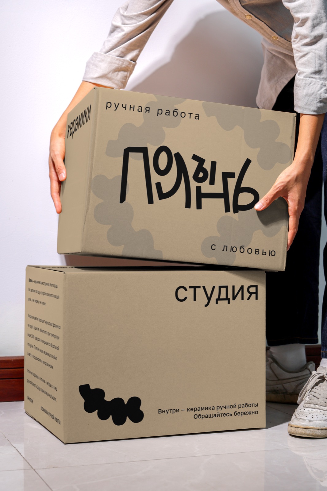 Коробки «Полынь» в руках, лицевая и тыльная грани